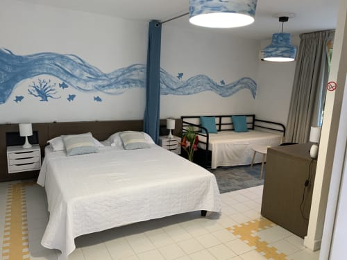 Appartement Studio Corail à St-François avec décoration murale océan bleu, lit blanc, canapé et mobilier moderne