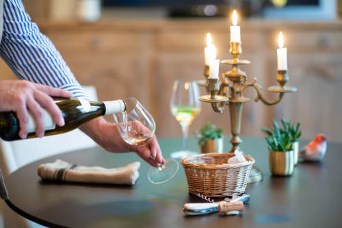 Personne versant du vin à une table élégante avec candélabre au Clos Saint Jacques B&B à Meursault