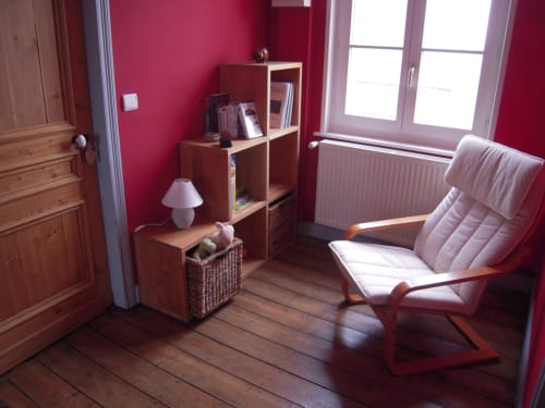Chambre cosy à La ferme de l'Ostrevent avec murs roses, mobilier bois et fauteuil relax à Estrées, France