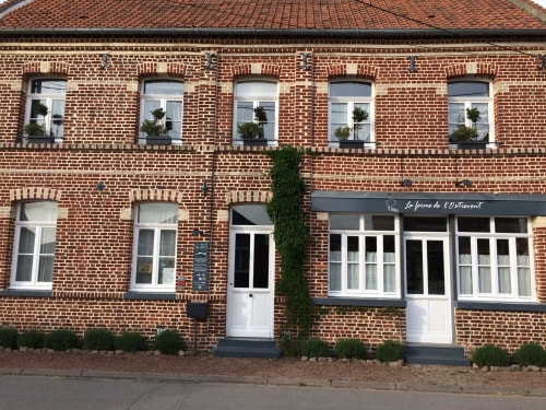 Façade en brique de la ferme de l'Ostrevent, gîte à Estrées, avec vitrines et lierre