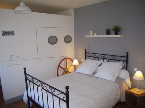 Chambre douillette à La ferme de l'Ostrevent B&B à Estrées avec lit en fer forgé, draps blancs et éléments décor.