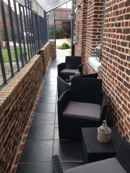 Petit patio couvert avec mobilier de rotin noir aux Chambres d'hôtes La ferme de l'Ostrevent, Estrées