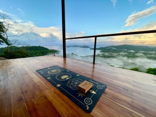 Tapis de yoga sur une terrasse en bois avec vue sur l'océan Pacifique et Isla Tortuga à Organica Yoga Shelter, Paquera, Costa Rica