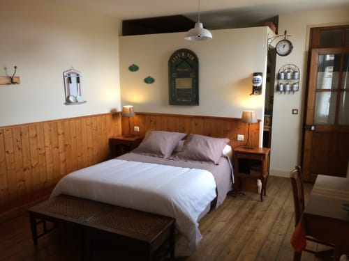Chambre chaleureuse à La ferme de l'Ostrevent avec lambris bois, lit blanc et décor rustique à Estrées