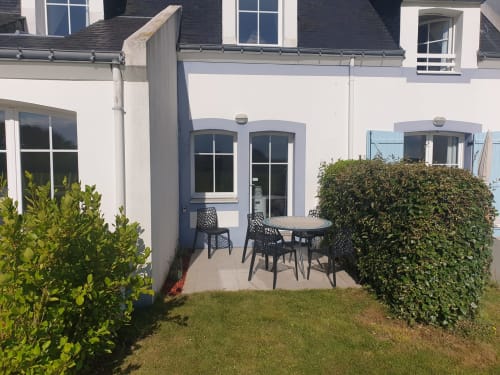 Patio moderne avec table et chaises de salle à manger, entouré de haies, à Loc'Maria Belle Île en Mer, Bretagne