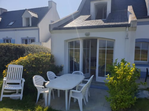 Terrasse d'appartement en bord de mer à Loc'Maria Belle Île en Mer avec mobilier blanc et vue sur le jardin
