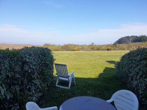 Coin salon avec vue sur les prairies verdoyantes et les haies du gîte Loc'Maria, Belle Île en Mer