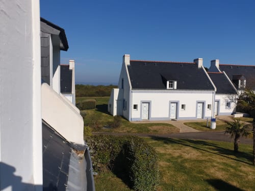 Cottages blancs aux toits sombres à Locations Loc'Maria, Belle-Île-en-Mer, avec jardin et pelouses entretenues sous le soleil