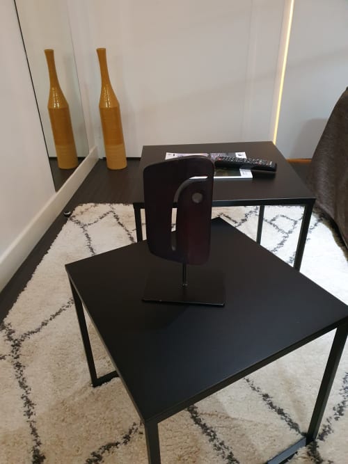 Coin salon moderne d'une chambre d'hôtel avec bureau noir, chaise et tapis à motifs à l'Hôtel Au Bon Coin à Biarritz