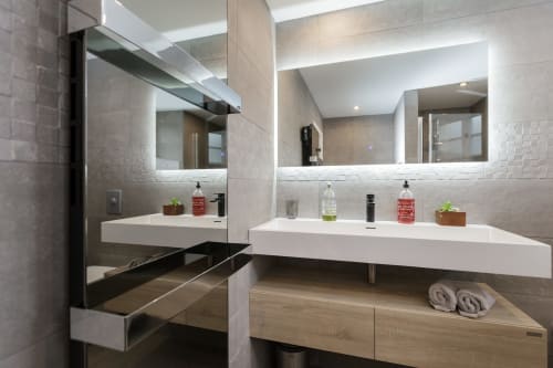 Moderne badkamer in hotel Moulin Renaudiots in Autun met dubbele wastafel, verlichte spiegels en houten opbergruimte