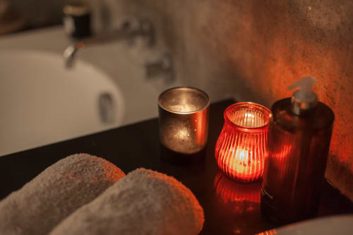 Luxe badkameromgeving in Moulin Renaudiots met rode kaarsen en zacht licht in de kamer St Andoche, Autun