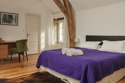 Rolinkamer in Moulin Renaudiots, Autun: bed met paarse sprei, houten balken, bureau, moderne voorzieningen