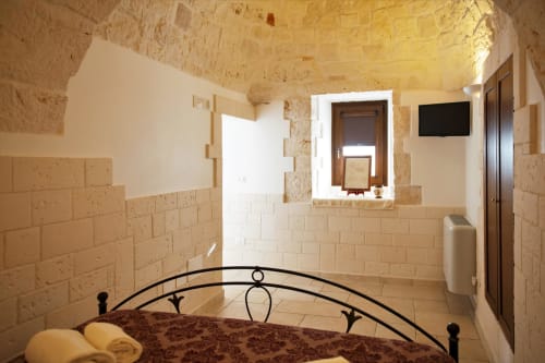 B&B Magraví ad Alberobello | Trullo Melograno in pietra con cucina, sala, bagno e doccia. Piscina esterna, colazione, wifi e parcheggio inclusi.