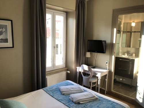 Modern double bedroom at Hôtel Maison Richet with TV, desk, en-suite bathroom and balcony access, Les Sables-d'Olonne