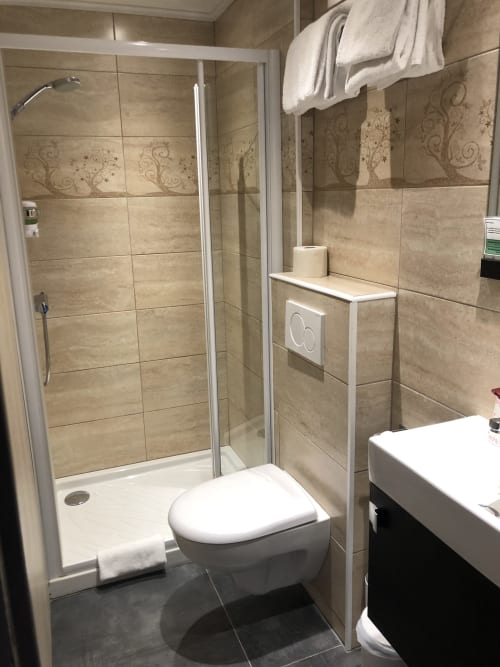 Modern bathroom with walk-in shower, toilet, and sink at Hôtel Maison Richet, Les Sables-d'Olonne