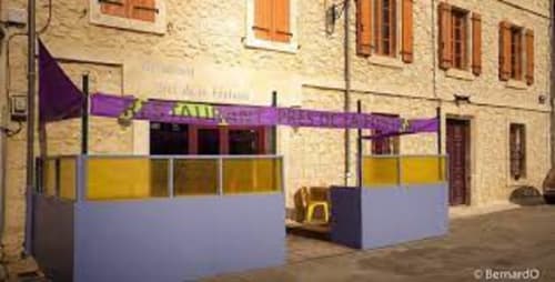 Terrasse extérieure du gîte Sylvie CAMBON avec auvent violet et panneaux jaunes à Montséret, France