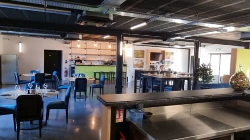Espace de salle à manger et cuisine moderne au gîte Sylvie CAMBON à Montséret avec chaises bleues et aménagement ouvert