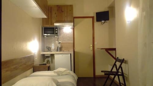 Compact studio at Residence Moliere Montrouge with bed, kitchenette, TV, and modern amenities