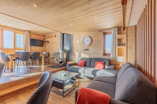 Modern wooden apartment living area in Bourg-Saint-Maurice with fireplace, seating, and mountain views