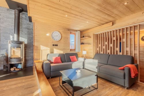 Cozy wood-paneled living room at Cosyarc apartment in Bourg-Saint-Maurice with modern furniture, fireplace, and mountain