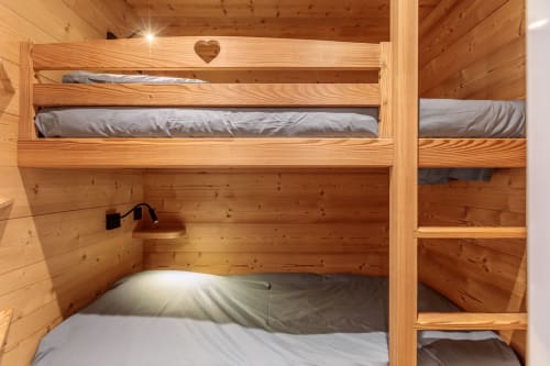 Wooden bunk bed with gray bedding in cozy Arc 1800 apartment, Bourg-Saint-Maurice ski resort