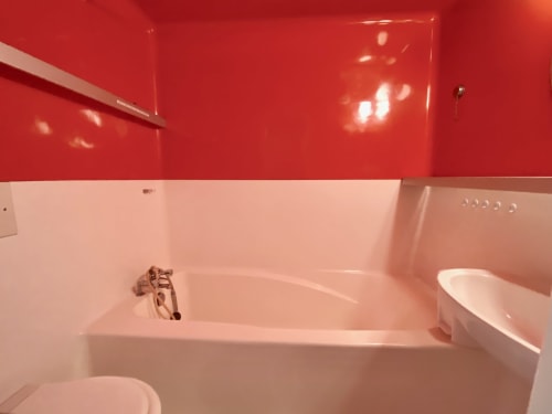 Iconic Charlotte Perriand bathroom with bathtub, sink, and toilet in the CosyArc Lauzières apartment in Arc 1800