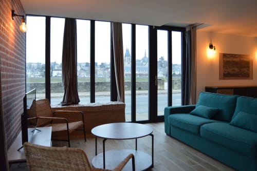 Modern living room with turquoise sofa, river views of Blois, Loire Valley through floor-to-ceiling windows