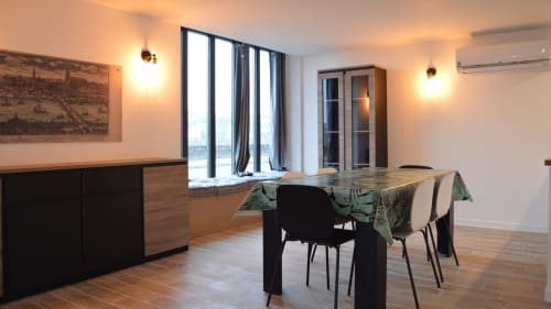 Modern dining area in Gîte Le Relais Viennois, Blois with river view windows, wooden furniture and ambient lighting