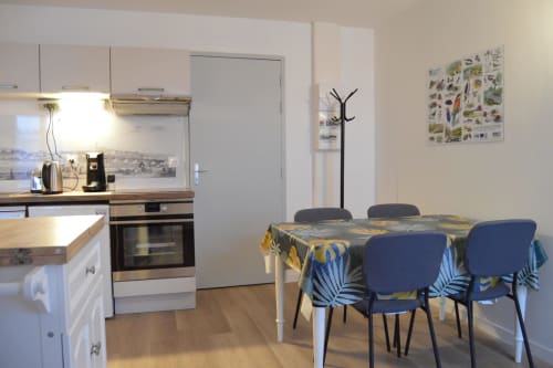 Modern cottage kitchen-dining area in Blois with blue floral chairs, equipped kitchen, and river view décor