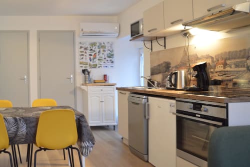 Modern kitchen and dining area in Blois cottage with yellow chairs and river view decor