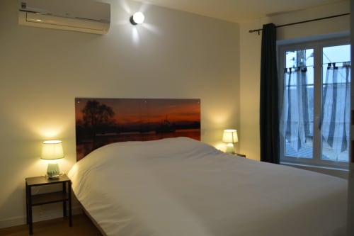 Modern bedroom at Locacharme cottage in Blois with river sunset view, air conditioning, and balcony access