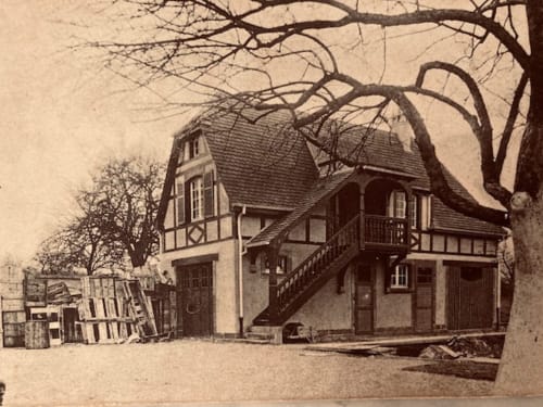 Historic half-timbered cottage at Le Clos d'Azel, a charming bed and breakfast in Alsace, France, with bare branches overhead