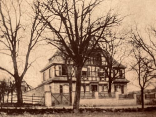Historic manor house Le Clos d'Azel in Alsace, France with bare winter trees and white fence