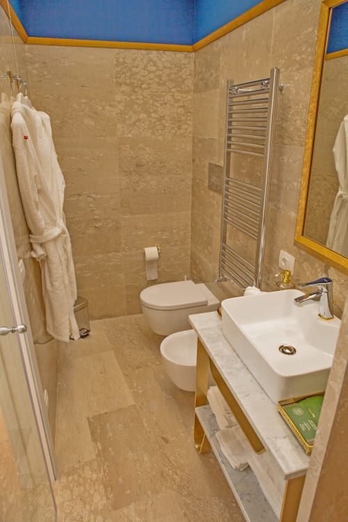 Junior Suite|  Piazza Posta - Dimora di charme nel centro storico di Procida. Camera matrimoniale con bagno privato, salottino, wifi gratuito, TV, colazione su richiesta, macchina Nespresso, climatizzazione, servizio navetta, giro in barca, personale multilingue