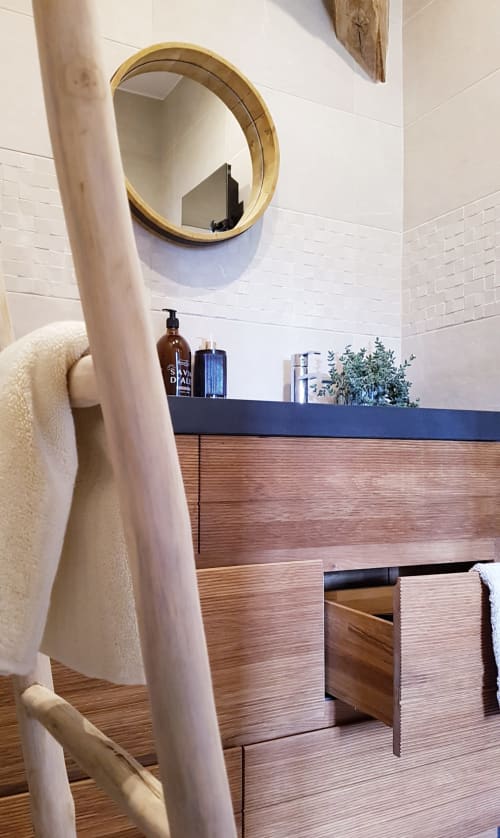 Moderne badkamer met rond gouden spiegel, witte tegelwanden en houten opbergruimte in Moulin Renaudiots-appartement in Autun