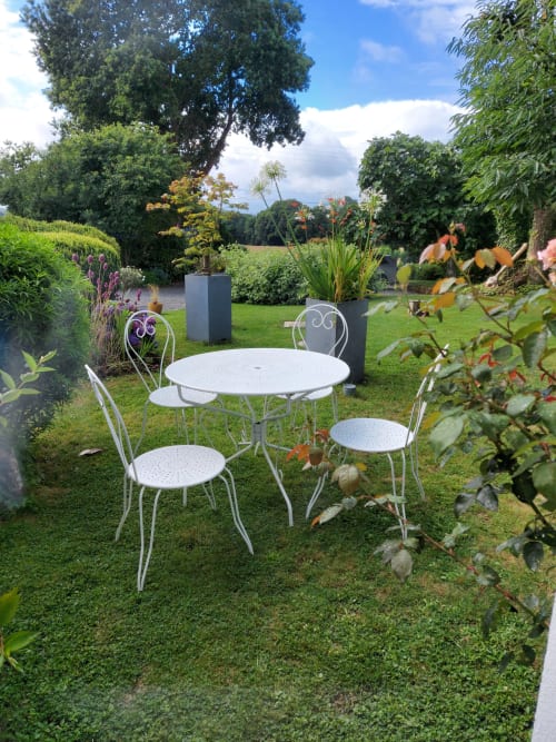Coin paisible pour manger dans le jardin de Ty Coz Breizh, chambres d'hôtes situées à Lorient, Bretagne Sud, avec une table en extérieur entourée de verdure, offrant un cadre tranquille et accueillant pour les repas en plein air