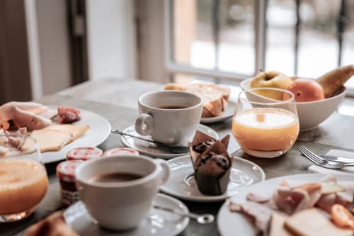 Petit déjeuner gourmand avec jus d'orange, fruits, café, viennoiseries