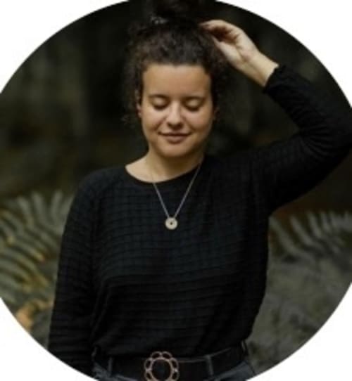 Property manager at Manoir de la Nogrie, Val d'Izé, smiling outdoors in black sweater