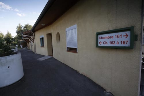 Passadís exterior de l'Hôtel Rocade a Pamiers amb senyal direccional per a habitacions 161-167