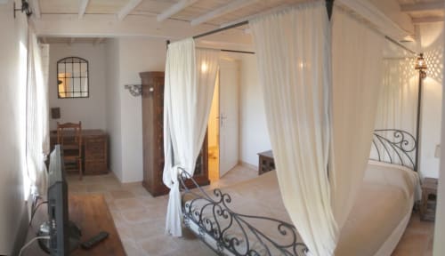 Chambre avec lit à baldaquin, armoire, coin bureau et TV