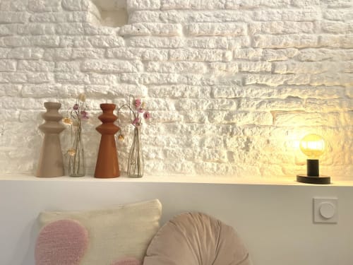 Étagère en brique blanche moderne avec vases en céramique, fleurs séchées et lampe suspendue chaleureuse dans la suite Plume de la Maison Monsieur