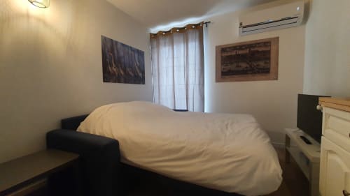 Modern bedroom at Locacharme cottage in Blois with white bedding, AC unit, and river view curtains