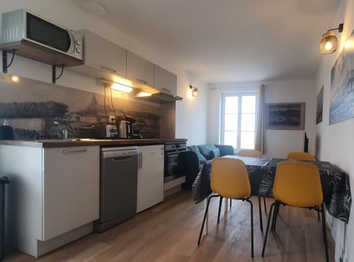 Modern cottage kitchen-living area at Locacharme Gîte, Blois with yellow chairs and river view