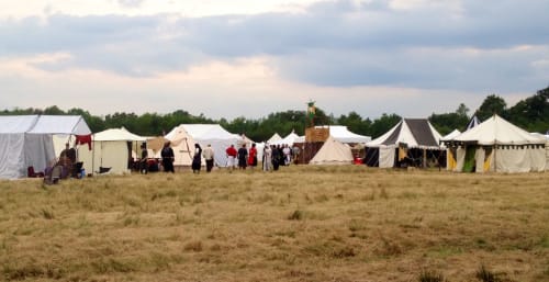 Campement de reconstitution historique avec tentes d'époque et visiteurs en costume près de Pruniers-en-Sologne