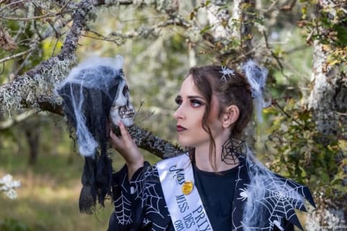 Femme en costume Halloween gothique avec maquillage de crâne parmi les arbres du Domaine des Bois Argentés