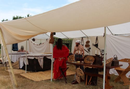 Camp de reconstitution médiévale au Domaine Des Bois Argentés avec tentes d'époque, visiteurs costumés et artisanat bois.