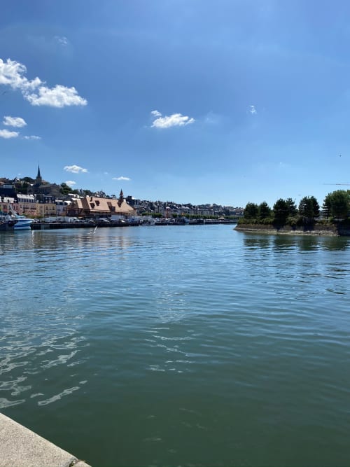 Vue pittoresque du village de Saint-Pierre-en-Auge avec son architecture historique et ses bateaux au bord de la rivière