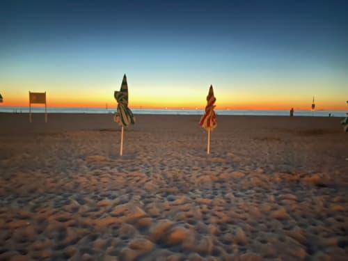 Plage au coucher de soleil avec parasols colorés et drapeaux, Domaine de Blanvatel, Saint Pierre en Auge