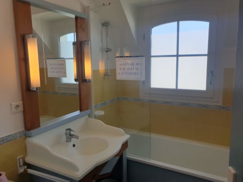 Salle de bain moderne avec douche, lavabo et miroir à l'appartement Locmaria Belle Île en Mer