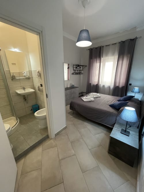 Neptune Room | Trastevere & Gianicolo Sweet Rest, Roma. Camera matrimoniale con bagno privato in camera con vista giardino interno, offre prodotti da bagno, bidet, WC, doccia, asciugamani, asciugacapelli, cucina attrezzata, piano cottura, forno, microonde, macchina da caffè, Tv, Netflix.